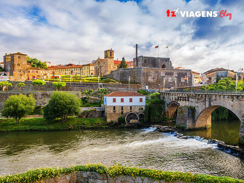 Barcelos em Portugal. É um ponto para conhecer em uma Viagem para Portugal. Na imagem a ribeira do rio que passa pela cidade. A ponte ao lado direito e ao fundo as ruínas e o castelo.