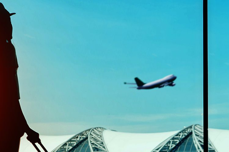 Mulher vendo o avião partir no aeroporto