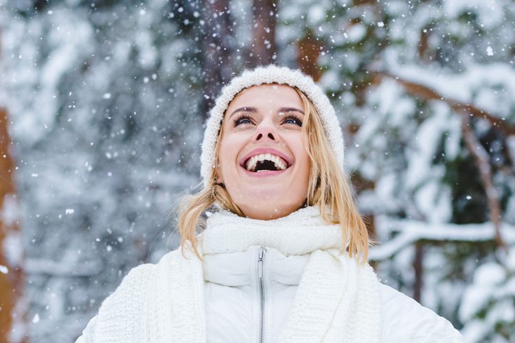 Mulher jogando flocos de neve para o alto