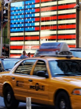Táxis trafegando pela rua da Times Square, destino ideal para uma viagem nos Estados Unidos